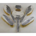 An engine-turned silver five-piece brush set, Birmingham 1922, to/w a small silver-backed brush,