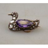 An antique amethyst and diamond set seated duck brooch with red stone eye, yellow gold and silver