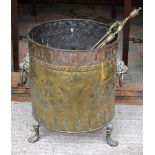 A 19th century cylindrical brass log-bin with two lion-mask and ring handles, on claw feet,