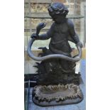 A Victorian style cast iron umbrella/stick stand modelled as a putti and serpent,