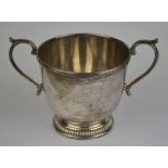 A two-handled silver sugar basin in the form of a porringer, on gadrooned foot-rim, Mappin & Webb,