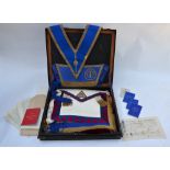 A Japanned tin box containing a collection of Bombay Masonic regalia, including aprons, sashes,