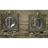 A pair of embossed brass girandole mirrors in the Baroque manner with circular bevelled plates and