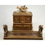 A Black Forest carved wood jewellery casket surmounted by birds and fitted with drawers,