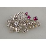 A ruby and diamond spray brooch white metal set