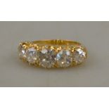 A Victorian style five stone ring of well matched old cut diamonds in yellow gold claw setting