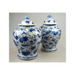 A matched pair of Chinese blue and white porcelain vases and covers each decorated with birds and