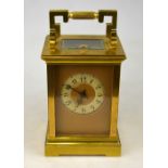 A French brass carriage clock with repeating movement, the gilt dial with enamelled chapter ring,