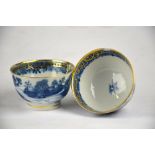 A pair of Chinese late 18th century blue and white tea bowls decorated with pagodas in a watery