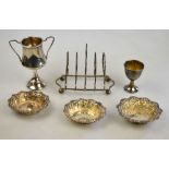 A four-division silver wire toast-rack on ball feet, Birmingham 1910, to/w a small trophy cup,