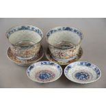 A pair of Chinese grains de riz bowls, stands and covers, each decorated with flowers and foliage,