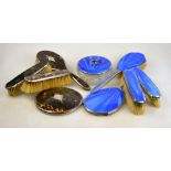 A silver and enamel five piece brush set including powder bowl and hand-mirror, London 1931,