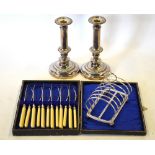 A pair of electroplated candlesticks with gadrooned rims, to/w a toast rack,