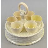 Belleek first period black mark 1863-90 - A circular basket weave egg cup stand with hand and ring