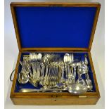 An oak canteen containing a mixed selection of flatware and cutlery, including Queen's pattern,