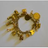 A 9ct yellow gold curb bracelet and padlock with nineteen various gold charms attached including