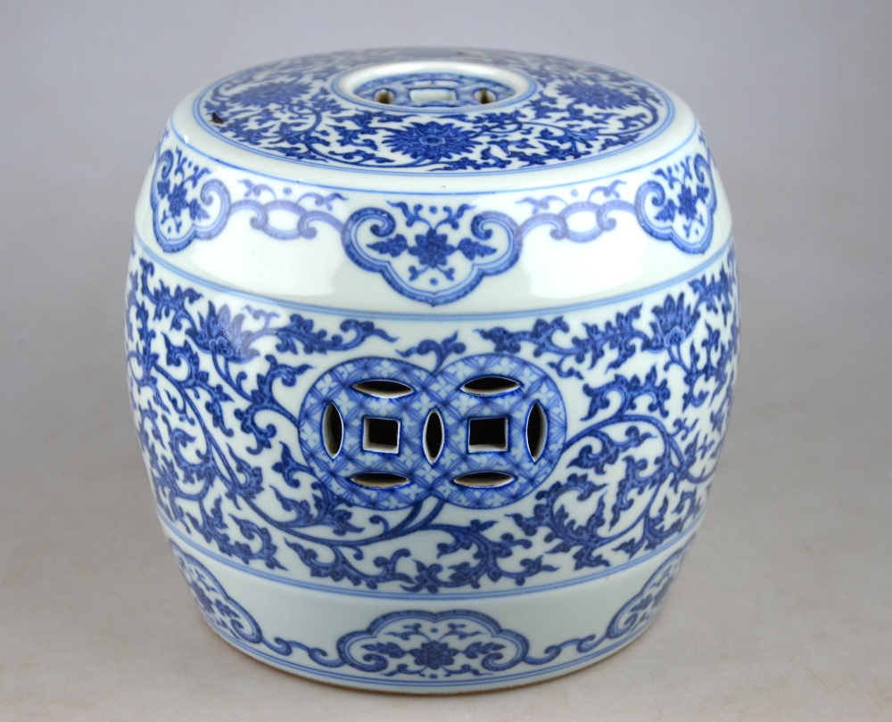 A Chinese blue and white small barrel garden seat decorated with a continuous floral and foliate