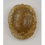 A 19th century Chinese agate pendant carved with a dragon to one side and calligraphy to the other,