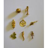 Eight various yellow metal charms - including bunch of bananas, telephone, shamrock, I Love You,
