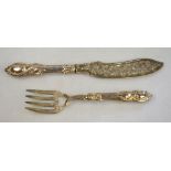 A pair of Victorian silver fish servers with engraved and pierced blades and ornate loaded silver