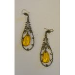 A pair of late Georgian long steel drop earrings having amber-coloured glass drop in centre,