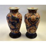 Japanese Meiji Period - a pair of large fluted Imari vases moulded with dragons contesting flaming