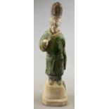 Chinese 10th century AD - a pottery funerary figure of a man wearing a green glazed robe,
