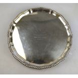 A silver salver with gadrooned rim, on three hoof feet, Collis & Co., Birmingham 1927, 28 oz, 32