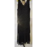 A 1930's black silk crepe evening dress embroidered with sunburst of diamante, with flared hem and