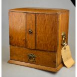 A Victorian light oak smokers cabinet with fitted pipe rack,