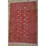 A Turkoman rug, 3rd quarter 20th century, having two rows of stylised guls on mid-red ground, 1.80 x