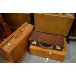 A tan, crocodile tooled tan leather travelling case with key and canvas cover,