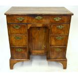 An 18th century walnut kneehole desk, the moulded edge top over an arrangement of seven drawers