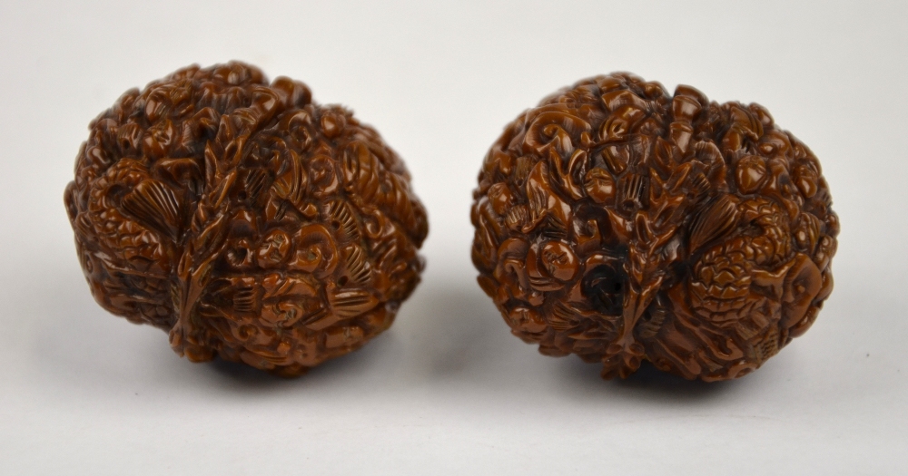 Two Chinese walnuts profusely carved with figures (2)