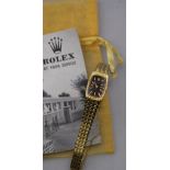 A lady's 14ct gold Rolex wristwatch with brown oblong dial and textured scale-link bracelet strap,