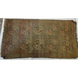 An antique Afghan long rug, brown/dark red ground,