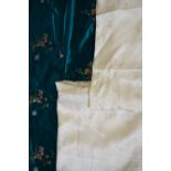 A vibrant jade green fabric bolt of Chinese silk with embroidered floral sprays and butterflies (