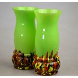 A pair of early 20th century green glass vases with enamelled pebble style decoration