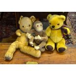 A vintage gold-plush teddy bear in worn condition,