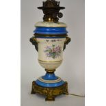 A painted ceramic oil lamp with globe shade,