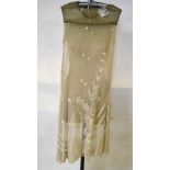 A cream net 1920's slip dress worked in the crewel-work style with floral sprays and roundels and