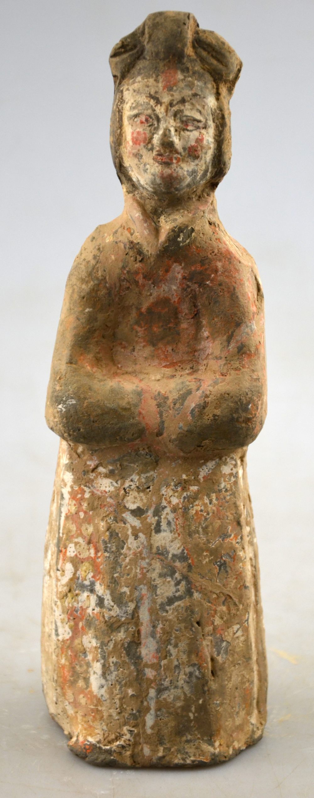 Chinese 5th century AD - a pottery funerary figure of a standing court lady, her arms folded,