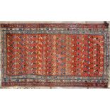 An antique Kurdish rug, the repeating stylised boteh design on rust ground, 1.80 x 1.02 m