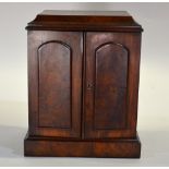 A Victorian figured walnut table cabinet having a caddy top over a pair of raised arched panel