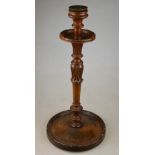 A turned and carved candlestick to/w a circular pipe rack incorporating a lidded tobacco store c/w