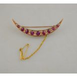 A ruby and diamond open crescent brooch