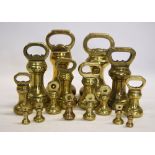 Two graduated sets of eight brass bell-weights,