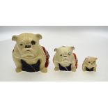 Three Royal Doulton graduated bulldogs draped in the Union Jack flag, 15 cm, 10 cm and 5.5 cm, the