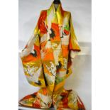 A Uchikake 1960's wedding kimono in vibrant orange and gold decorated with cranes in flight