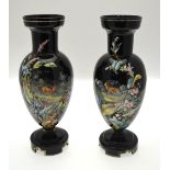 A pair of Victorian black glass baluster vases enamelled with stags in a landscape bordered by